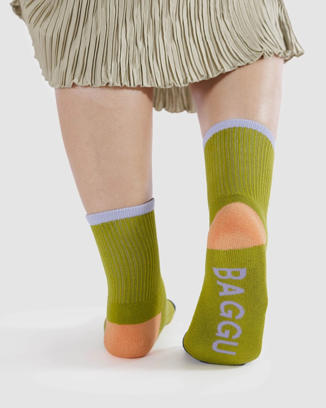 Lemongrass pair of socks of feet with navy blue coloured toes and orange heels