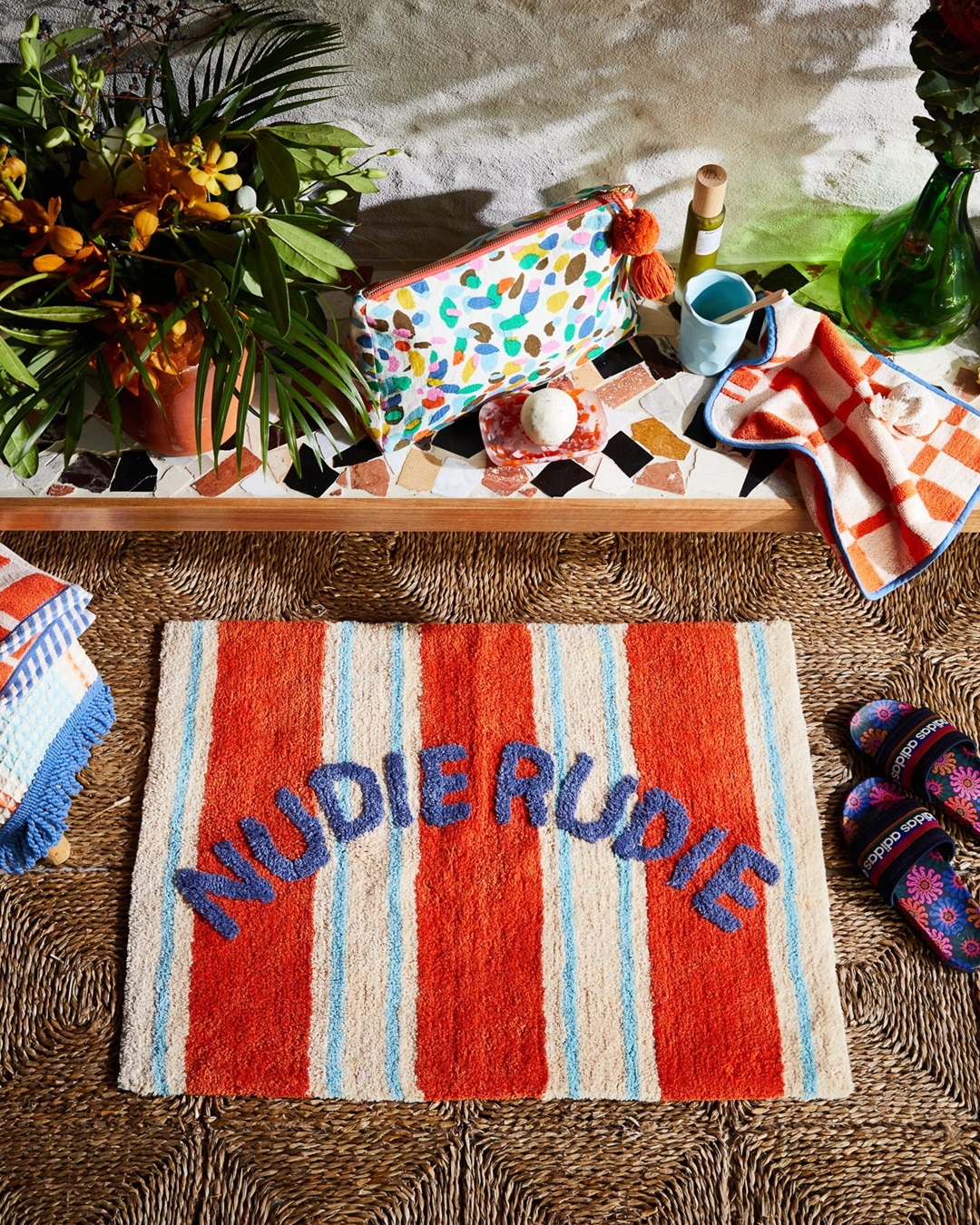 Orange and blue stripe Nudie Rudie bath mat on floor