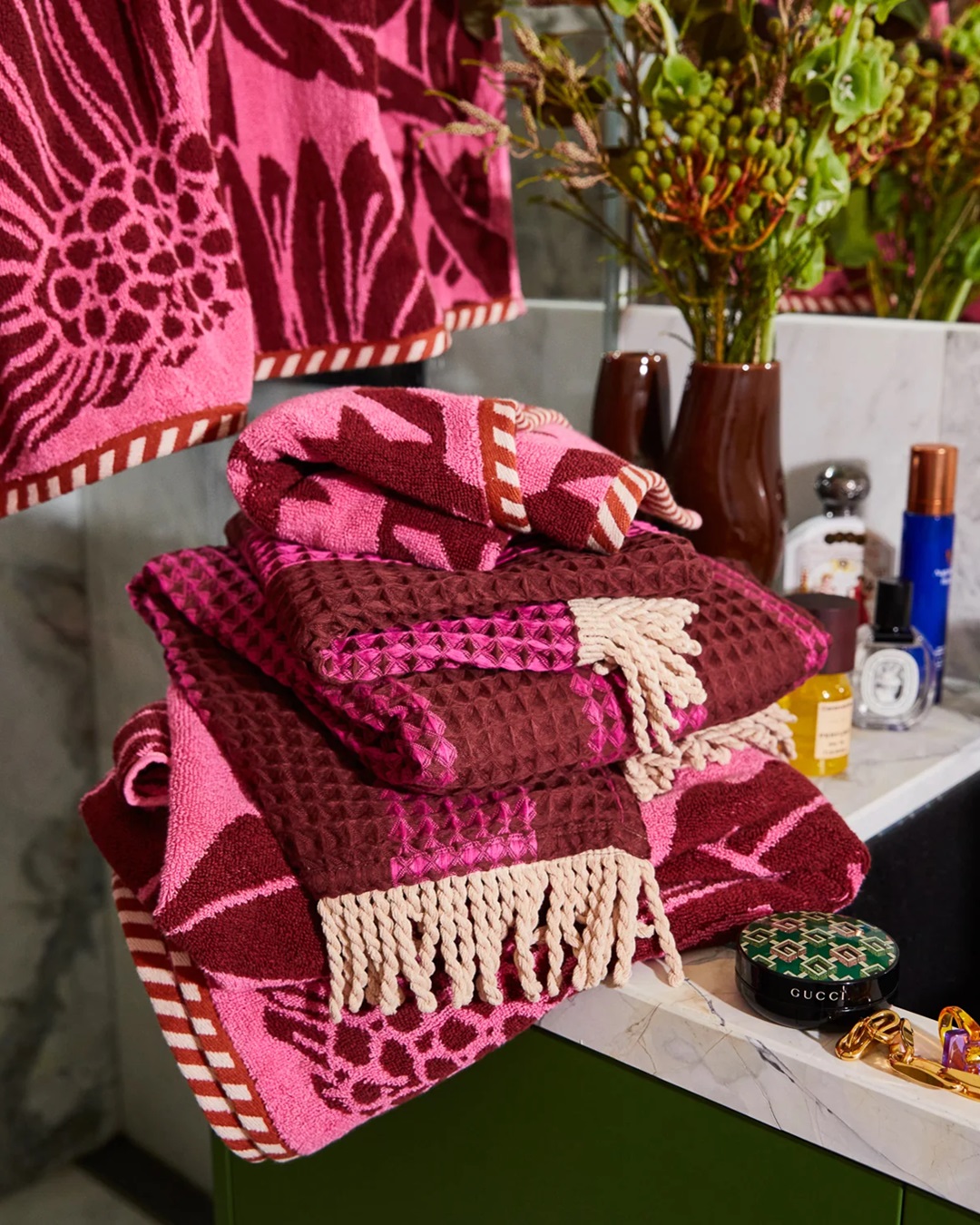 Pink floral bath towels folded on sink