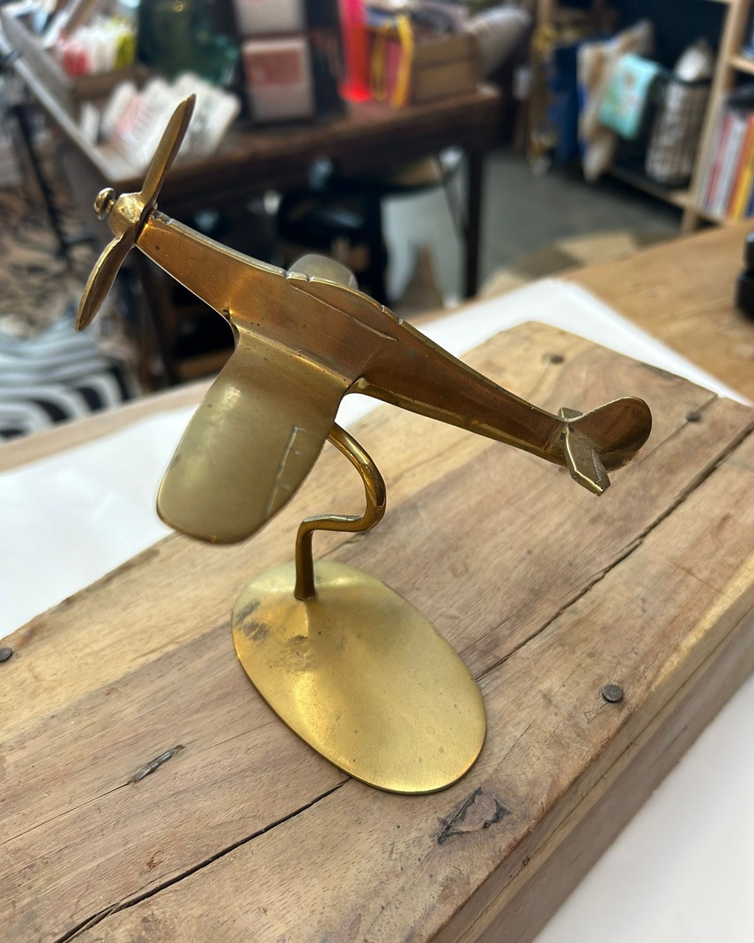 Brass aeroplane on wooden table