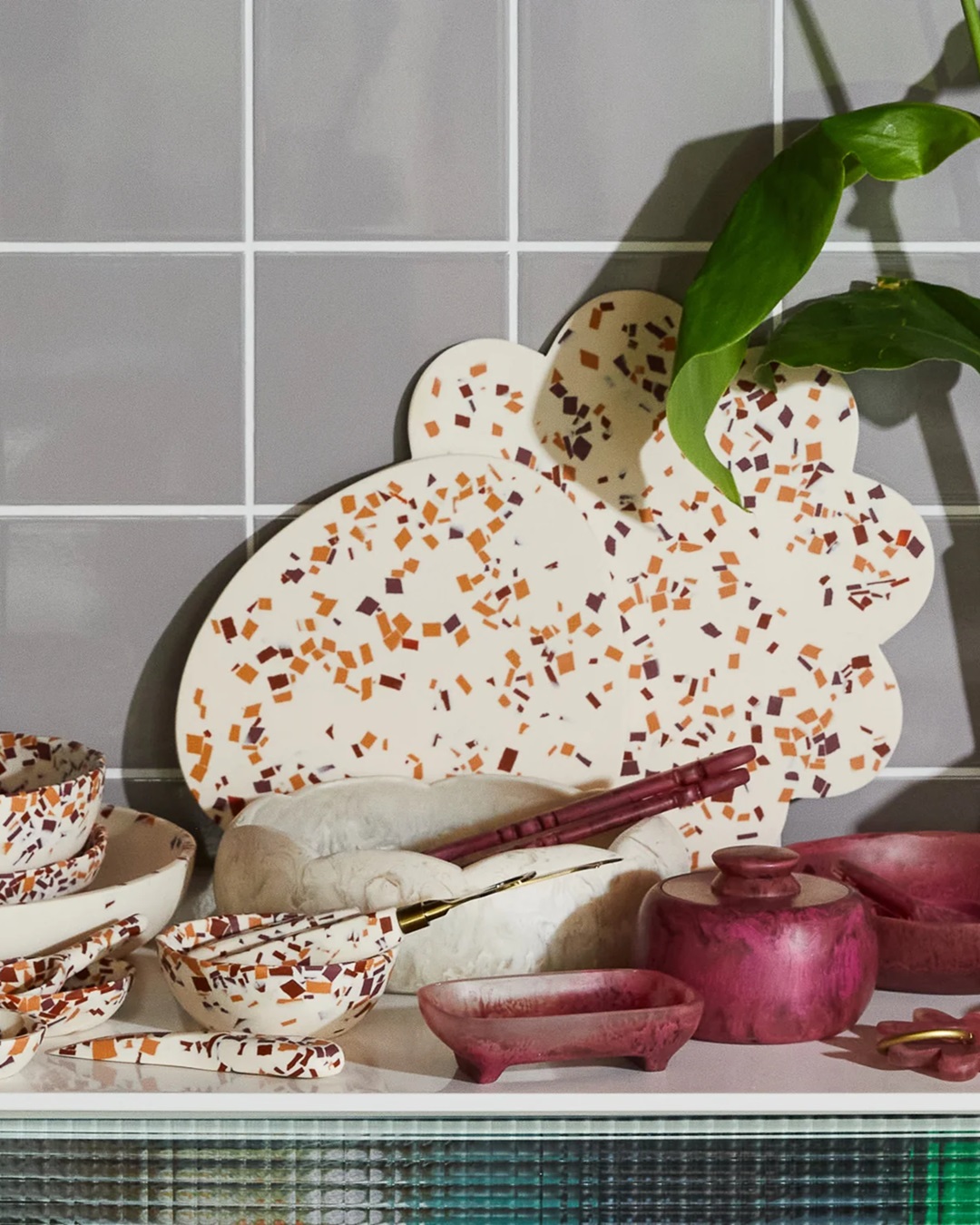Board in red and orange terrazzo on shelve with other bowls