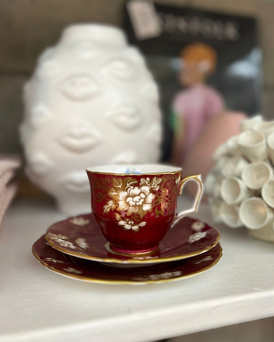 Red flower china cup on saucer on shelf