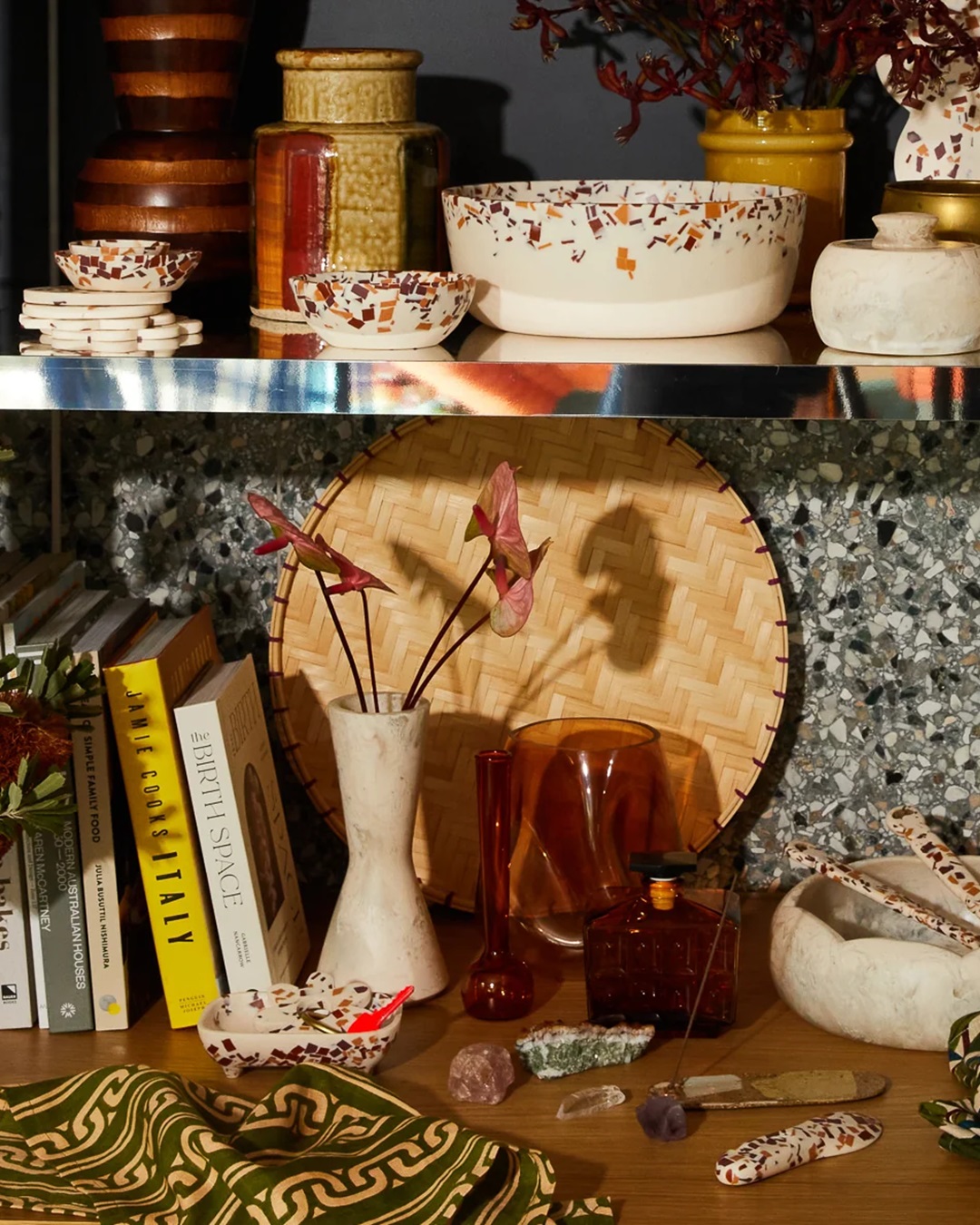 Cream coloured resin vase on shelf with books an other household items