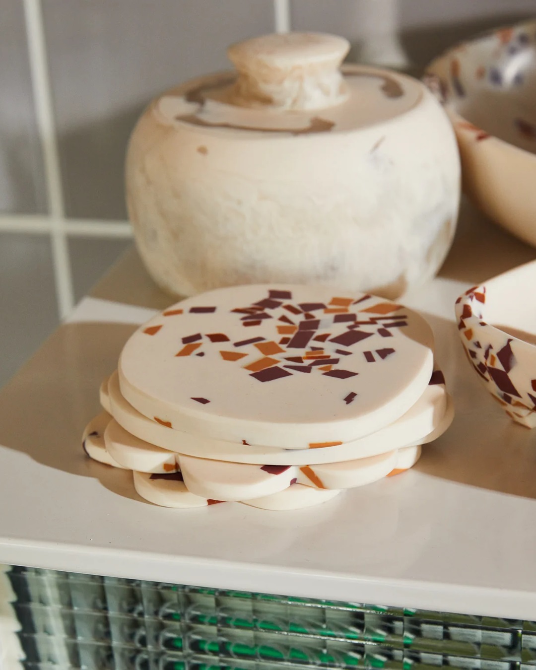 White orange and red coasters stacked on table