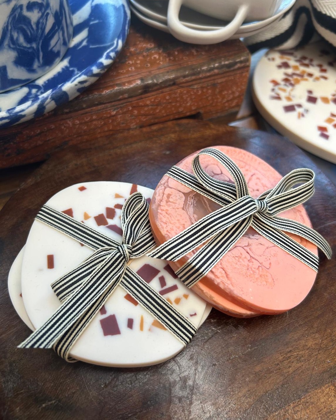 White and orange coasters tied with ribbon on wooden bench