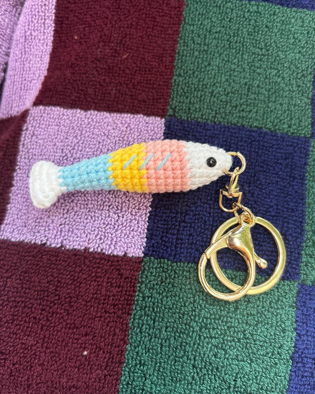 Knitted fish keyring on towel