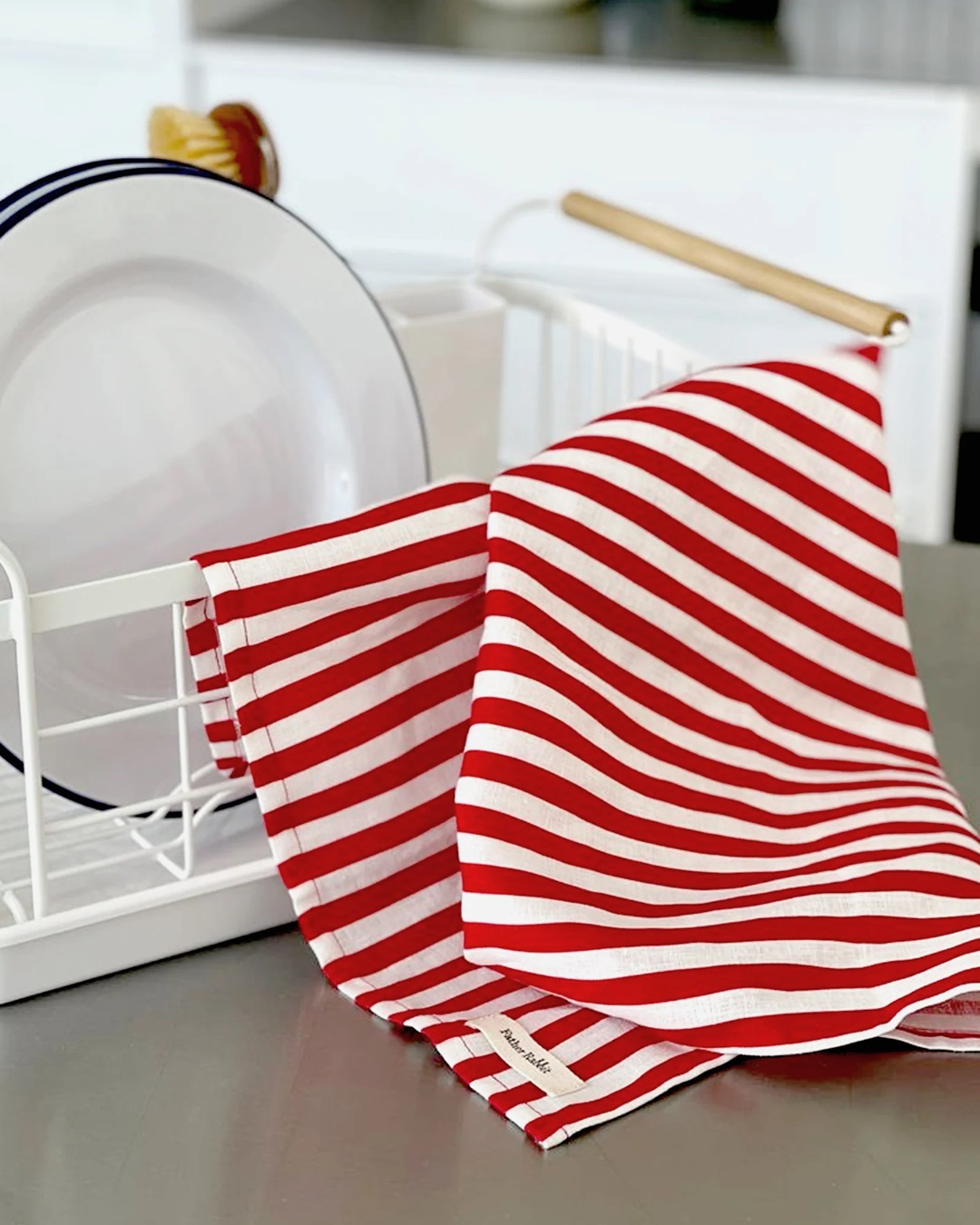 red and white stripe tea towel on dish rack