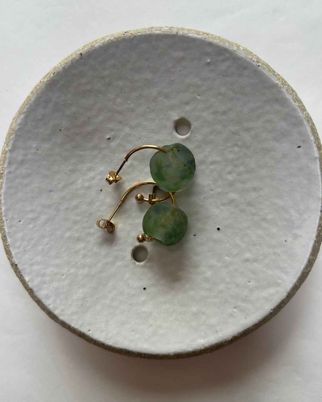 Java sea glass stud earrings on white plate