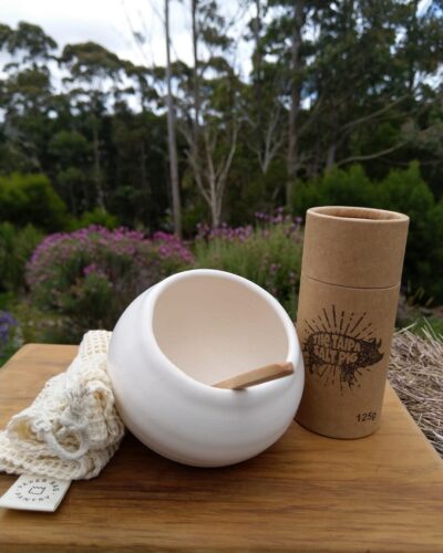 Salt bowl in white with container of salt and cloth next to it