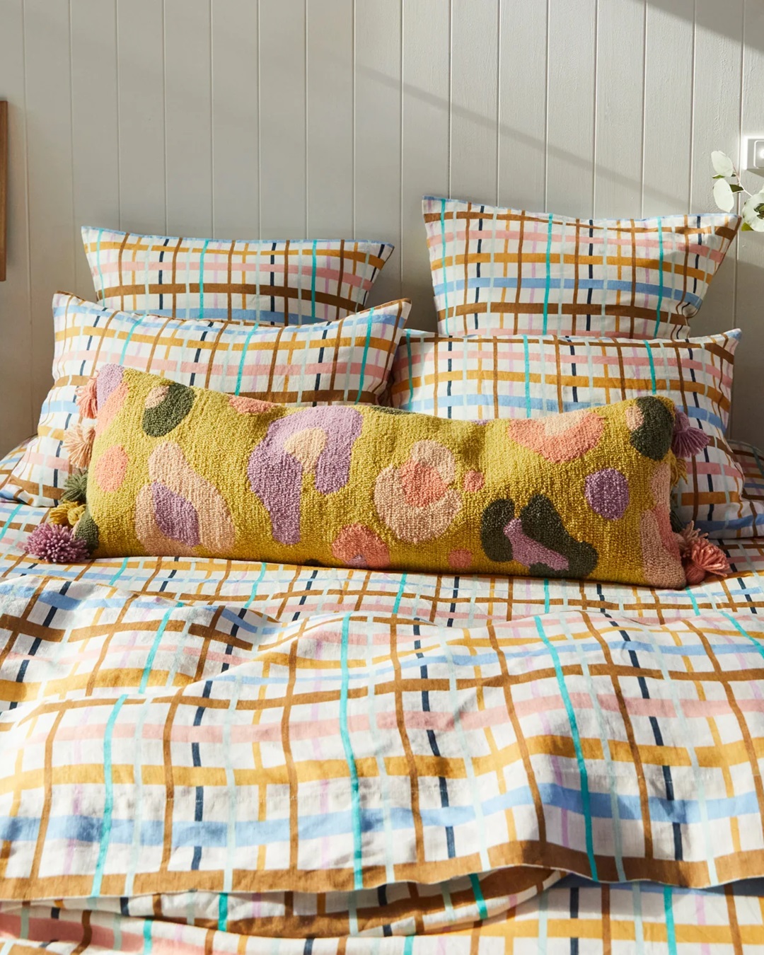 Yellow leopard rectangle cushion with tassels on pin stripe bed