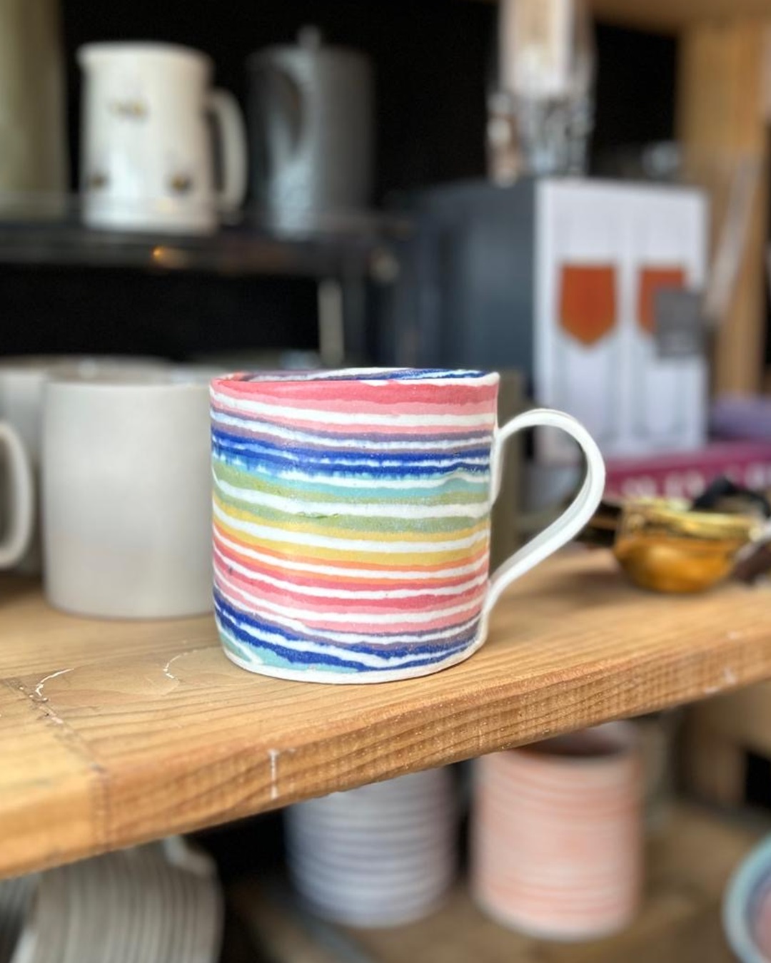 Rainbow ceramic mug on shelf