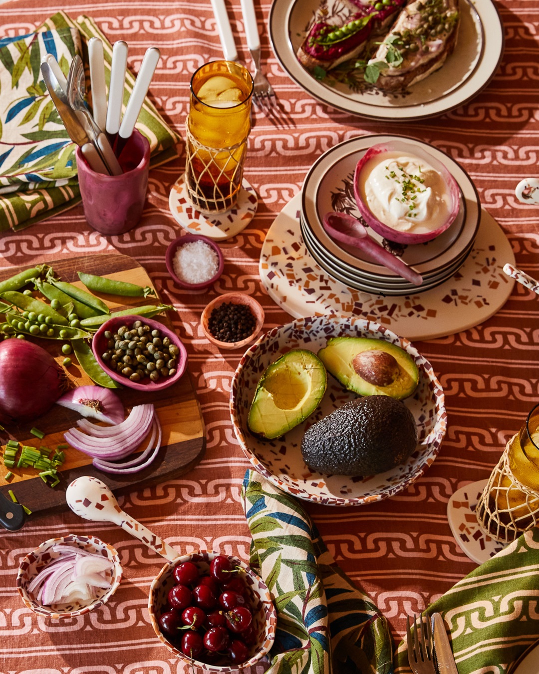 Food in terrazzo bowls on red and orange tablecloth