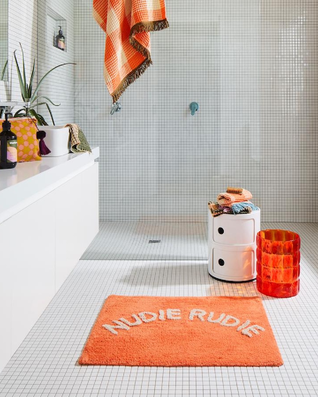 Orange Nudie Rudie bath mat in bathroom on floor