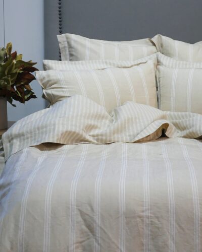 Off white striped duvet set on bed with ruffled duvet