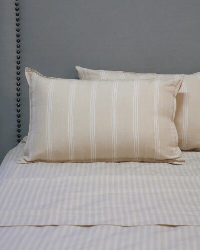 Off white striped pillowcases on bed