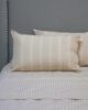 Off white striped pillowcases on bed