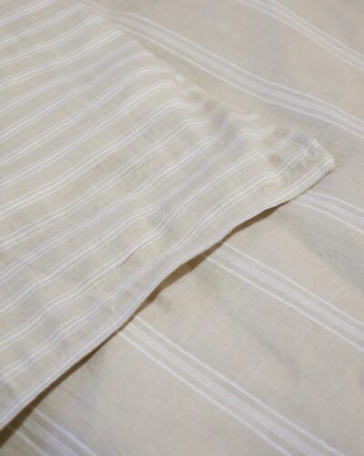 Off white striped empty pillowcase on duvet