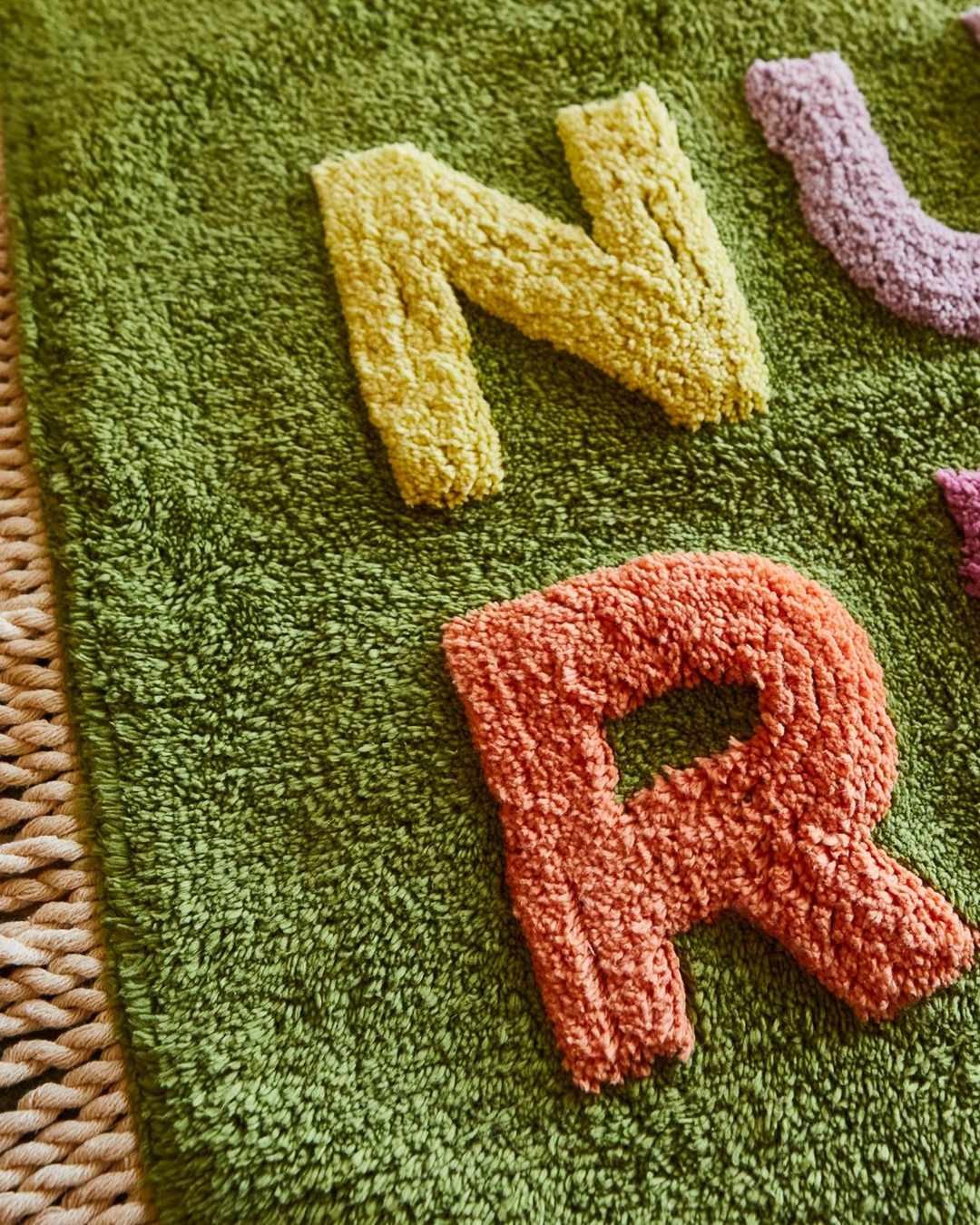 Green Nudie Rudie Bath mat with yellow N and orange R