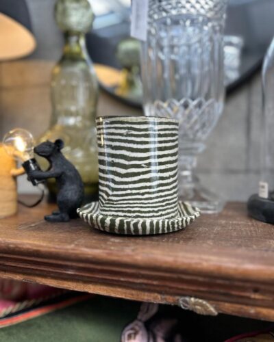 Dark green striped planter with saucer on wooden shelf