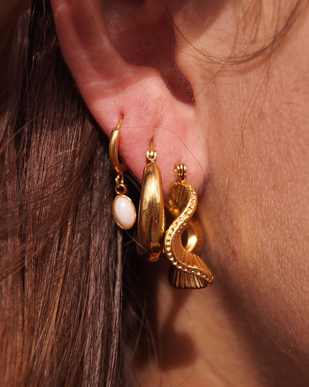 Gold hoop earrings in ear