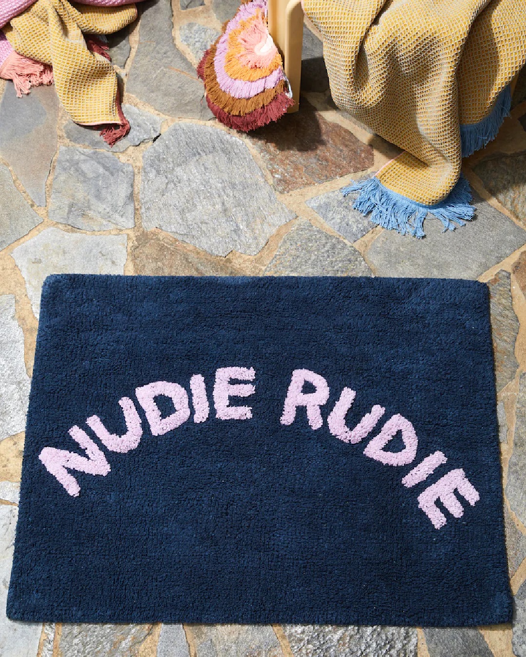 Blue and pink Nudie Rudie bath mat on bathroom floor