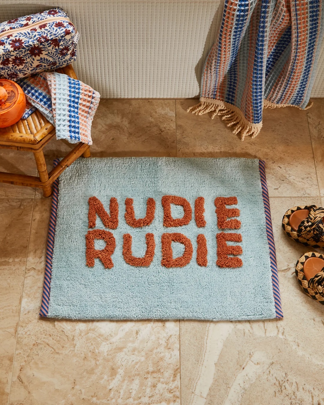 Blue and brown Nudie Rudie Bath Mat on bathroom floor