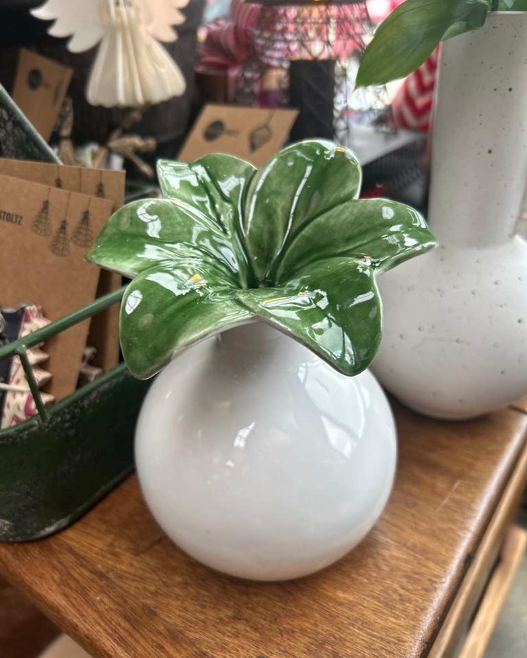 Green and white flower vase on wooden table