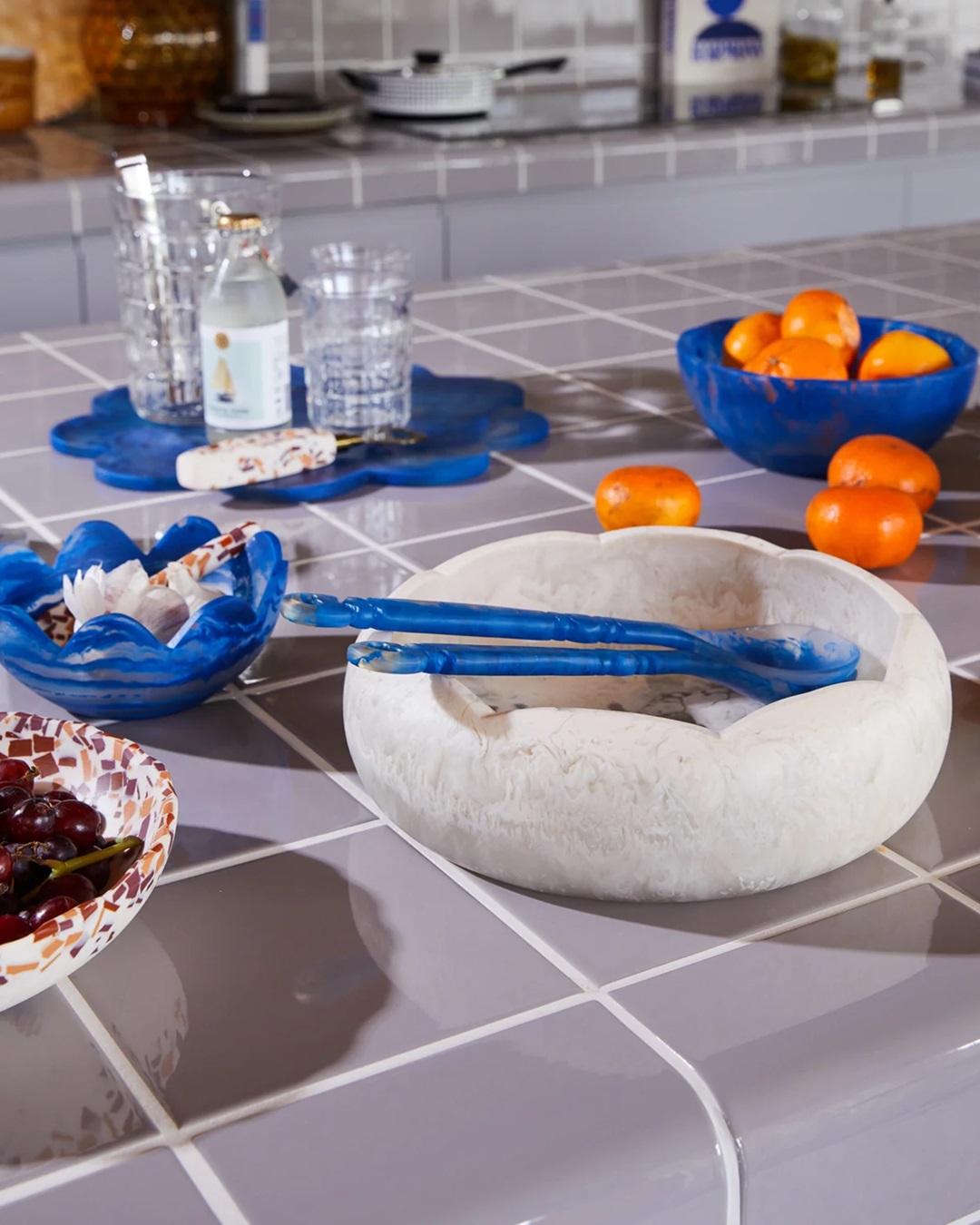Blue resin salad servers in bowl on kitchen bench