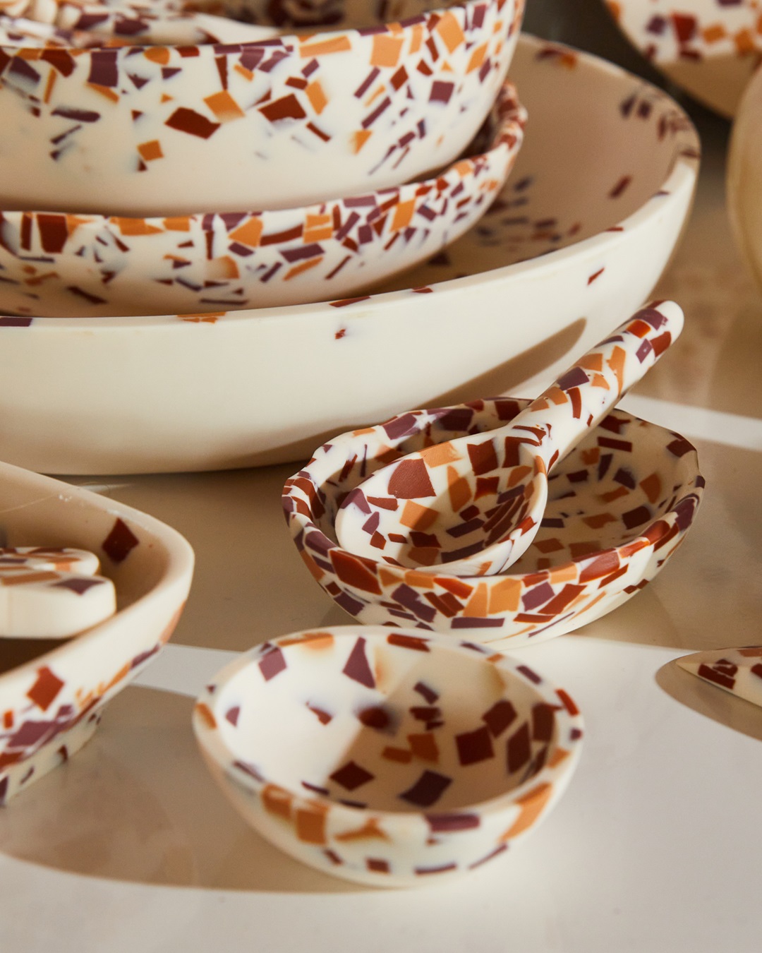 Red and orange terrazzo bowls and spoons on table